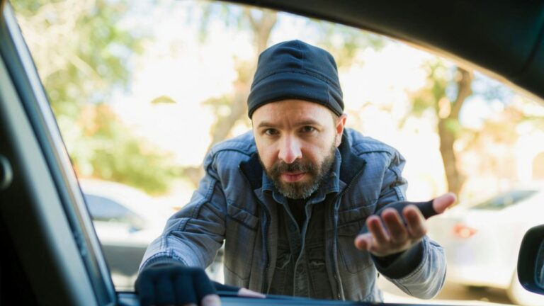 Man says a homeless-looking stranger came running at his car while he was parked with food — and he kept the 9mm hidden by his knee while the guy pounded on the window and demanded money